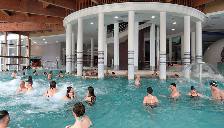In Les Grands Bains du Monetier kun je zwemmen en bubbelen in warme binnen- en buitenbaden, maar ook ontspannen in sauna's en stoomcabines. © WintersportFrankrijkGids.nl